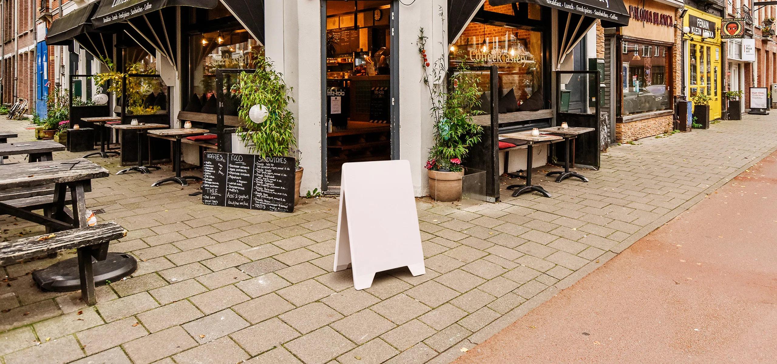 Dwustronny potykacz reklamowy z PVC z ustawiony przed restauracją
